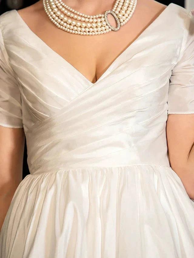 1950s vintage short A-line wedding dress with V-neck, short sleeves, ivory satin bodice and gathered waist.