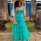 Woman in turquoise strapless tiered gown outside blue and white house, ZAPDRESS fashion