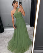Woman in elegant green one-shoulder evening gown posing for a mirror selfie, ZAPDRESS style.