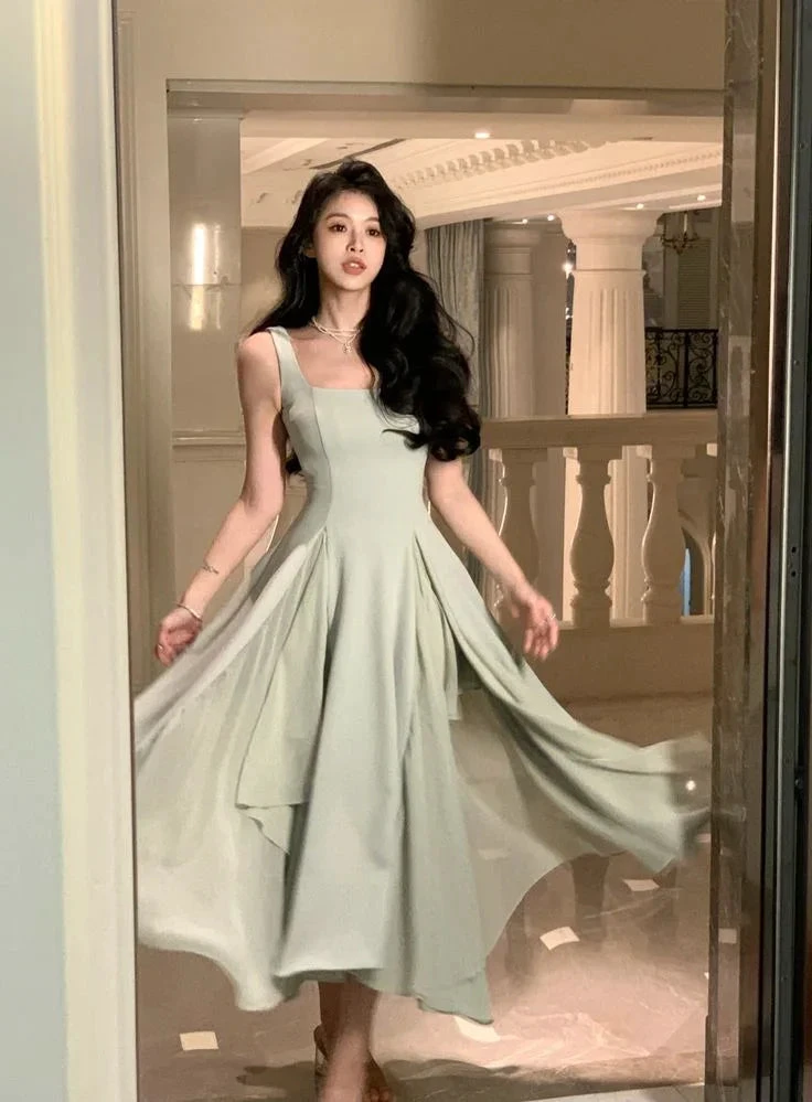 Woman in elegant light green flowy dress at luxurious venue, ZAPDRESS fashion