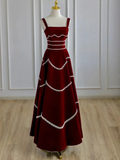 Elegant burgundy maxi dress with white trim on mannequin, wood floor, ZAPDRESS fashion