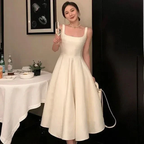 Woman in elegant white midi dress holding a champagne glass, ZAPDRESS formal fashion