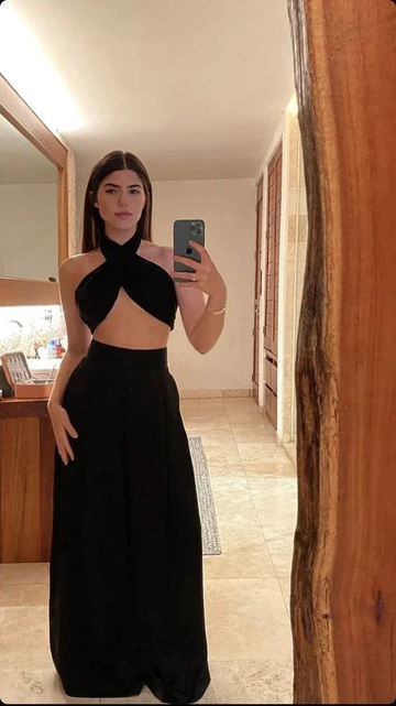 Woman wearing a chic black cut-out dress taking a mirror selfie, ZAPDRESS fashion style