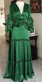 Elegant green satin maxi dress with ruffled sleeves and tiered skirt displayed indoors