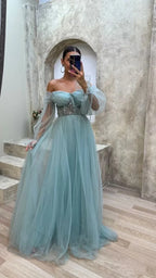 Woman in light blue off-shoulder tulle evening gown with sheer sleeves at ZAPDRESS