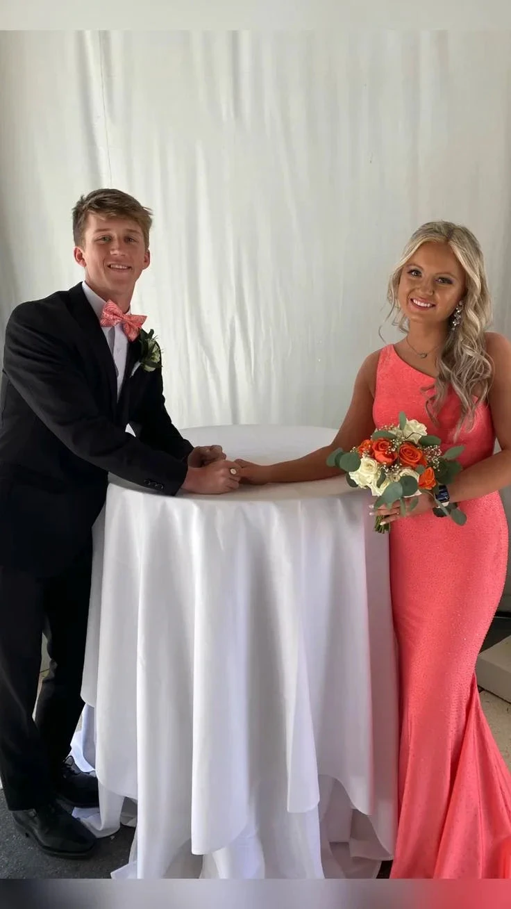 Young couple in formalwear, woman in coral pink dress holding bouquet, ZAPDRESS style