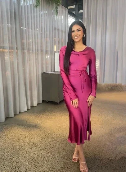 Woman in a long-sleeve magenta satin dress standing indoors, ZAPDRESS fashion style