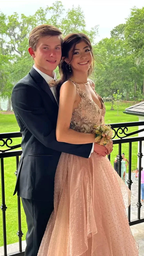 Teen couple in formalwear with pink prom dress and corsage on outdoor balcony, ZAPDRESS style