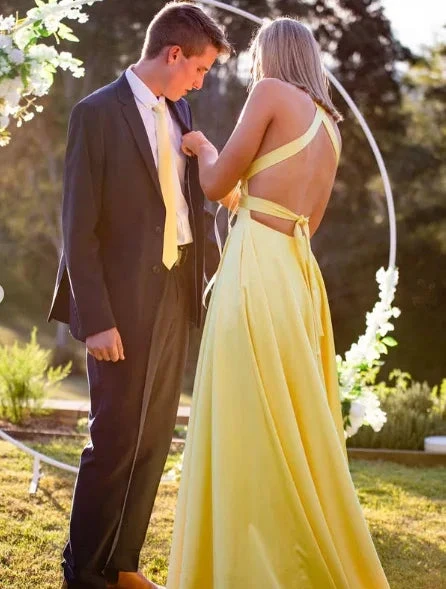 Woman in yellow backless dress and man in suit at outdoor event, ZAPDRESS style