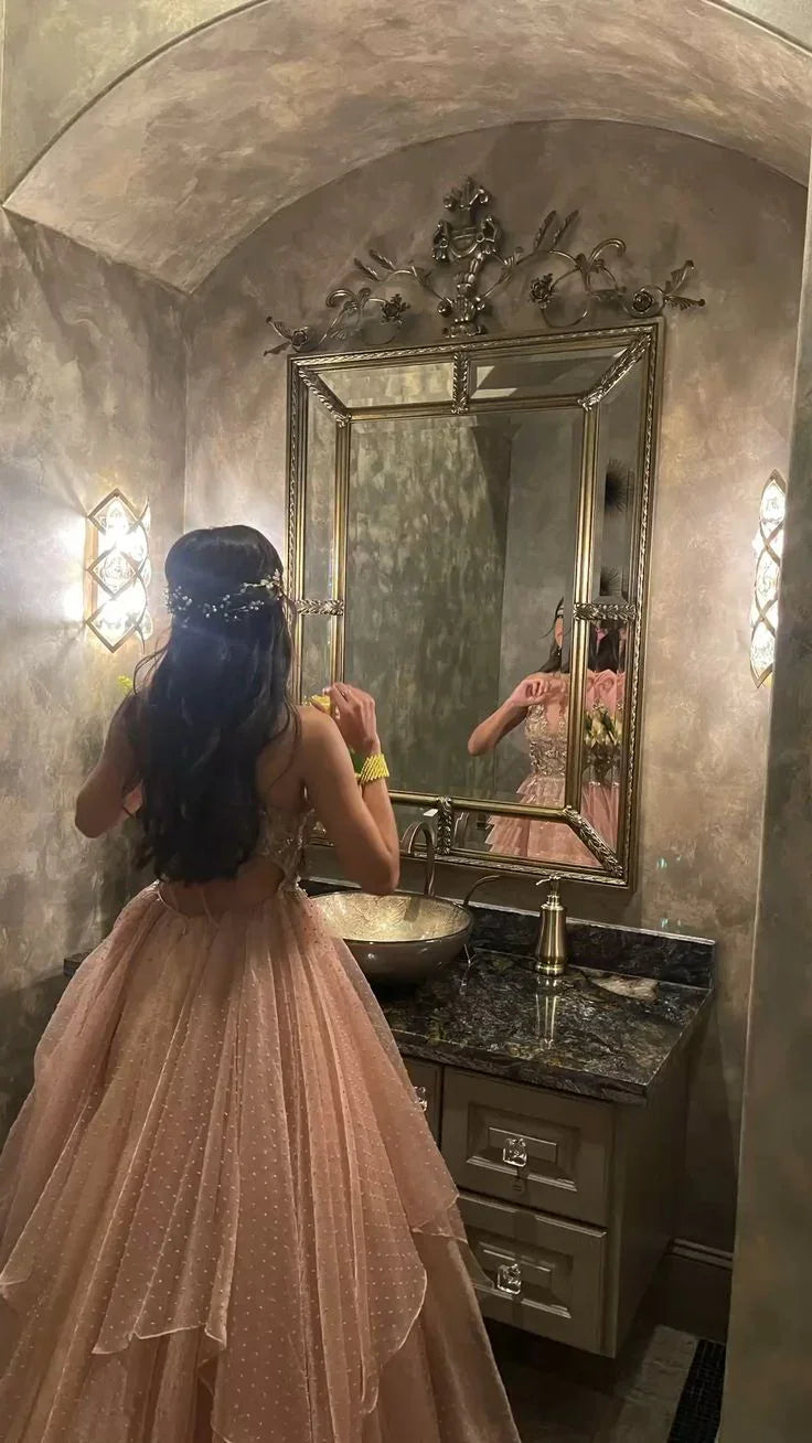 Woman in elegant pink ball gown at ornate bathroom vanity with mirror, ZAPDRESS fashion