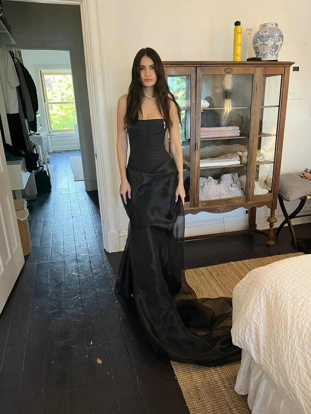 Woman in elegant black evening dress standing in bedroom, ZAPDRESS fashion style