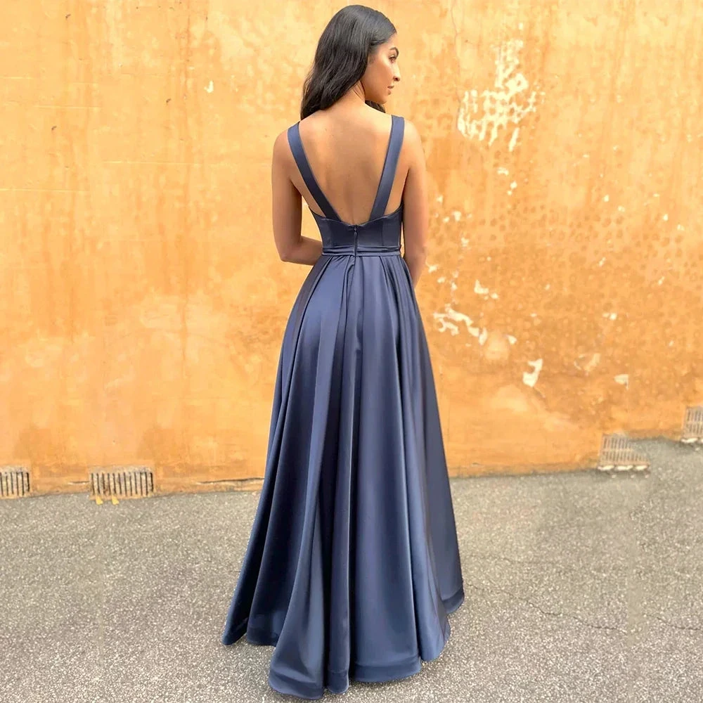Woman in elegant navy evening gown with deep V-back from ZAPDRESS, outdoor setting