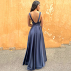 Woman in elegant navy evening gown with deep V-back from ZAPDRESS, outdoor setting