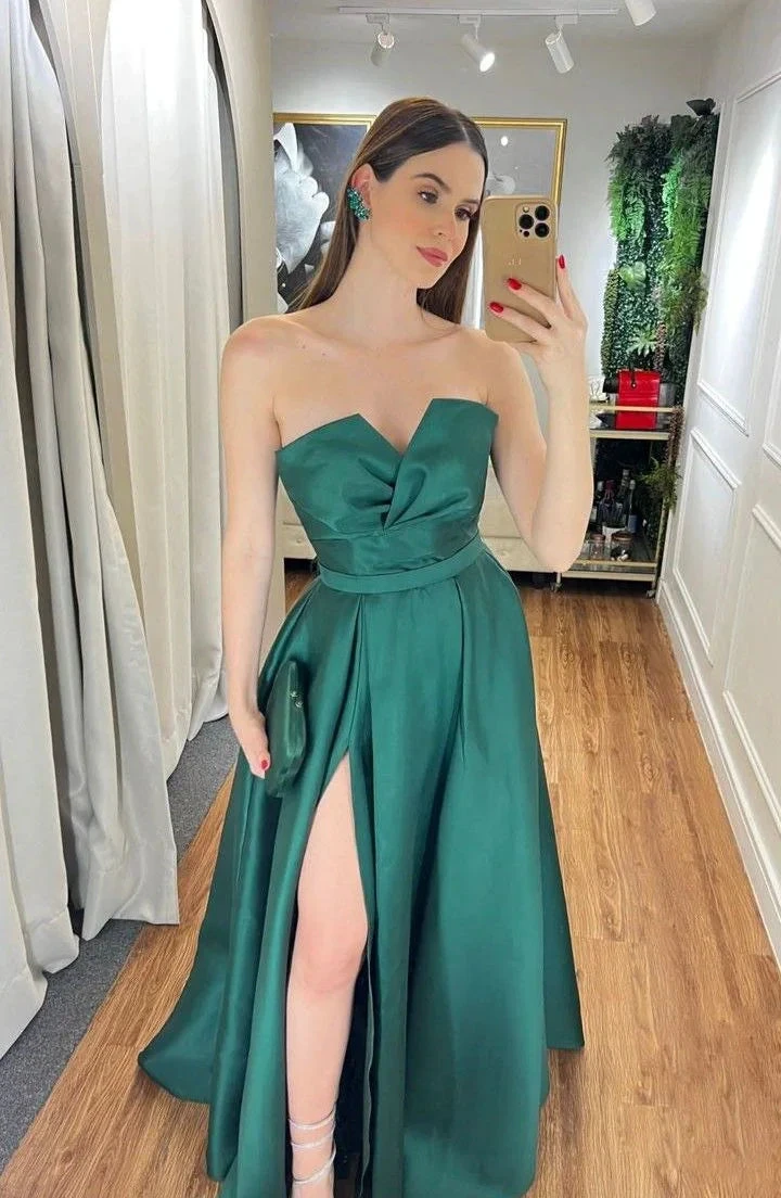 Woman in emerald green strapless evening gown taking mirror selfie at ZAPDRESS boutique