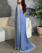 Woman in elegant blue embellished evening gown from ZAPDRESS, standing indoors