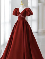 Elegant burgundy ball gown with puff sleeves and floral accents on display at ZAPDRESS