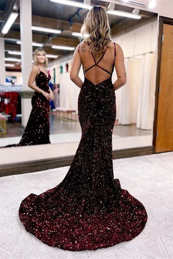 Woman in a sparkly burgundy backless evening gown with train, standing in front of a mirror at ZAPDRESS.