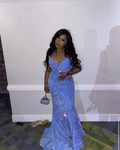 Woman in sparkling blue evening gown with silver purse at ZAPDRESS event