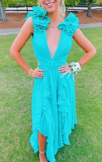 Woman in turquoise ruffle dress with deep V-neck at outdoor event on grass, ZAPDRESS style