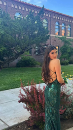 Woman in green sequin backless dress posing outdoors by brick building, ZAPDRESS fashion