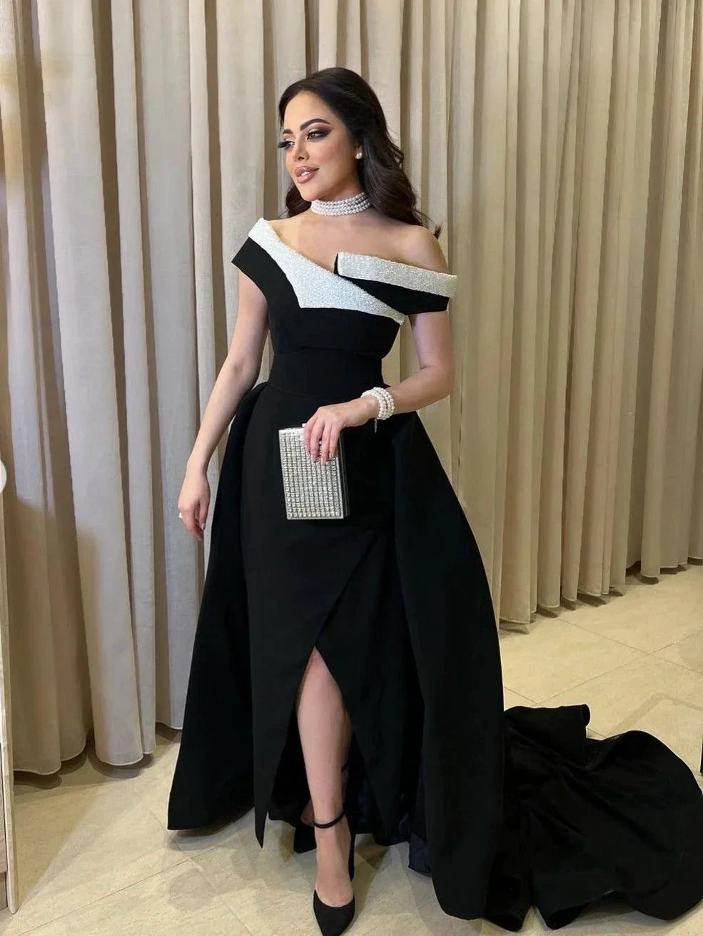 Elegant woman in a black and white off-shoulder evening gown with jeweled accessories, ZAPDRESS