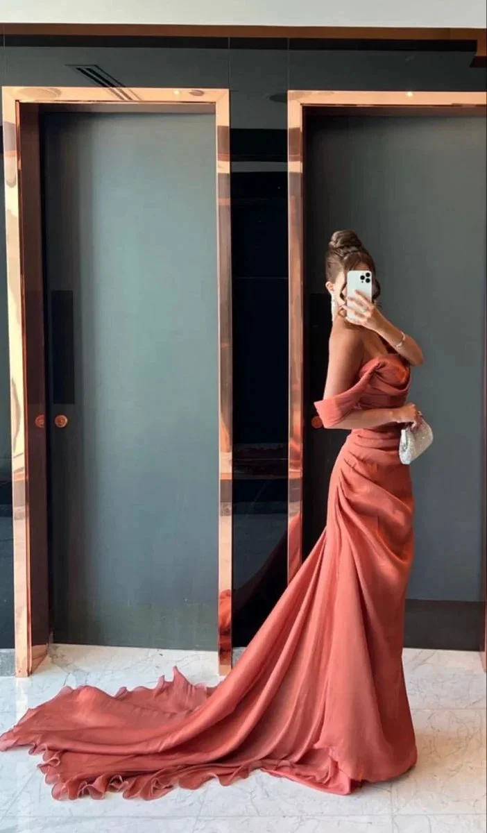 Woman in elegant off-shoulder rust satin evening gown taking mirror selfie, ZAPDRESS fashion