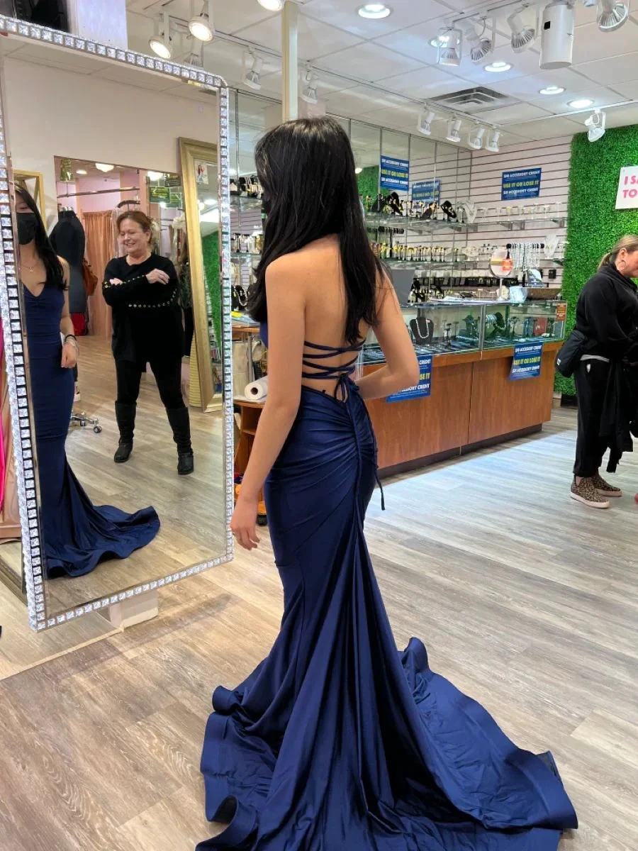 Woman trying on navy blue backless evening gown at ZAPDRESS boutique