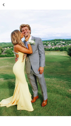 Woman in yellow formal dress kisses man in grey suit on grass, ZAPDRESS fashion style