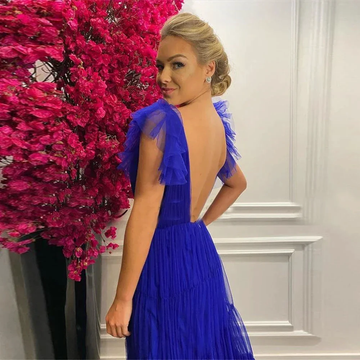 Woman in royal blue backless dress by ZAPDRESS near vibrant pink flowers indoors