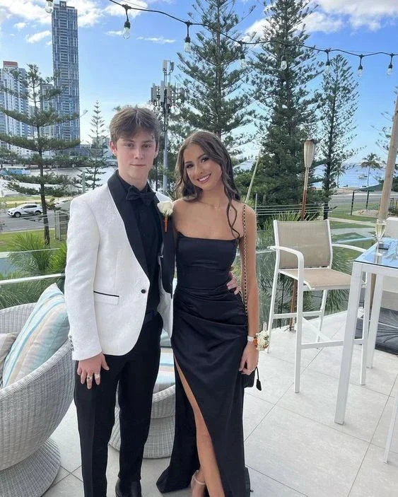 Young couple posing outdoors in formalwear, woman in black dress, man in white tuxedo, ZAPDRESS style