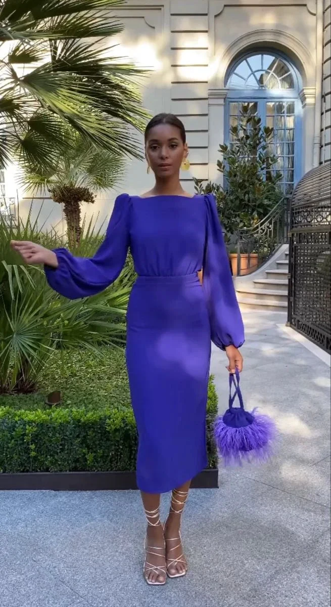Woman in a vibrant purple midi dress holding a matching feathered bag outdoors, ZAPDRESS style