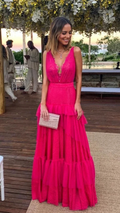 Woman in a vibrant pink ruffled maxi dress holding a clutch, outdoor event at ZAPDRESS