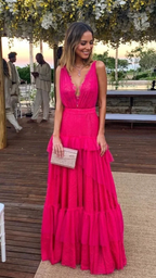 Woman in a vibrant pink ruffled maxi dress holding a clutch, outdoor event at ZAPDRESS