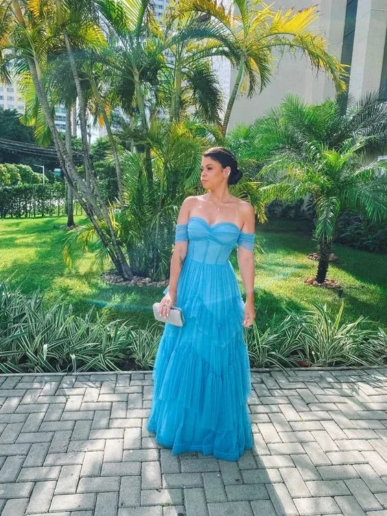 Woman in a blue off-shoulder dress standing outdoors with palm trees, ZAPDRESS fashion