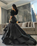 Woman wearing elegant black ruffled evening gown in luxurious living room, ZAPDRESS fashion