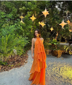 Woman in flowing orange ruffle dress standing outdoors at sunset with glowing star lights, ZAPDRESS