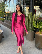 Woman in a shiny magenta satin midi dress from ZAPDRESS, standing outdoors by green plants