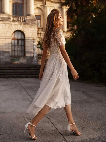 Vestidos de novia de corte A con escote corazón, apliques de encaje, botones y mangas cortas de tul. 