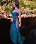 Woman in elegant green sheer evening gown at event with floral backdrop, ZAPDRESS fashion
