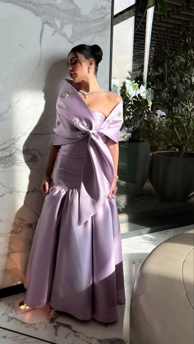 Elegant woman in a lilac satin gown with floral embellishments at ZAPDRESS, marble backdrop