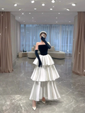 Woman in tiered white ruffle skirt and black strapless top posing indoors, ZAPDRESS fashion
