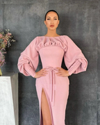 Woman in pink puff sleeve dress with front slit, posing against dark wall, ZAPDRESS fashion