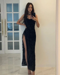 Woman wearing elegant black evening dress with thigh-high slit, standing indoors, ZAPDRESS
