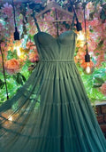 Elegant green tulle dress on hanger, displayed with flowers and lights, ZAPDRESS fashion