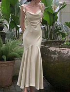 Woman in pale yellow satin evening dress with ruffle sleeves, garden background, ZAPDRESS style