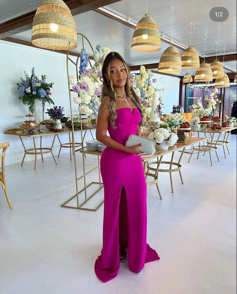 Elegant woman in a vibrant pink evening gown at a decorated event table, ZAPDRESS fashion