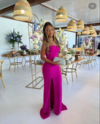 Elegant woman in a vibrant pink evening gown at a decorated event table, ZAPDRESS fashion