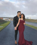 Woman in elegant maroon evening gown and man in black suit on road, ZAPDRESS fashion style