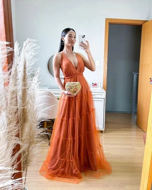 Woman in a long orange evening dress takes a mirror selfie in a modern bedroom, ZAPDRESS fashion