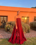Woman in strapless red maxi dress holding matching bag, sunset outdoors at ZAPDRESS